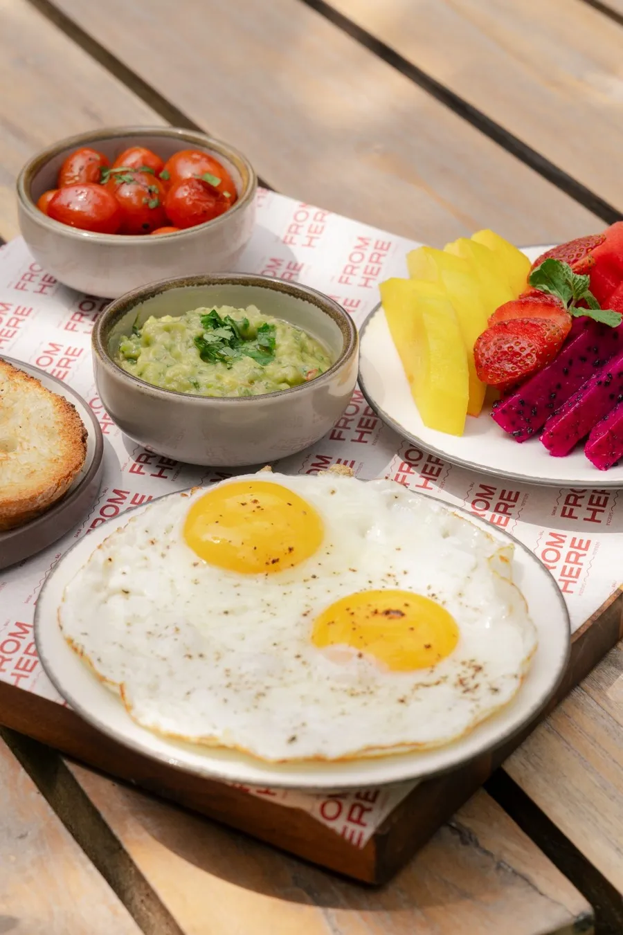 Breakfast spread with fried eggs and fresh fruits.