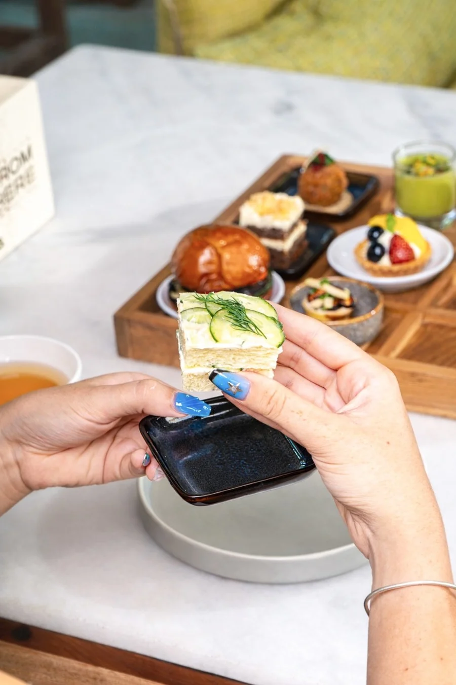 Person holding a small dessert over a table