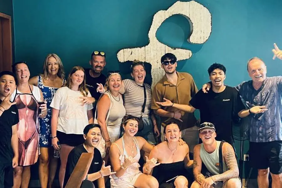 Group smiling together in front of Frankie’s logo.